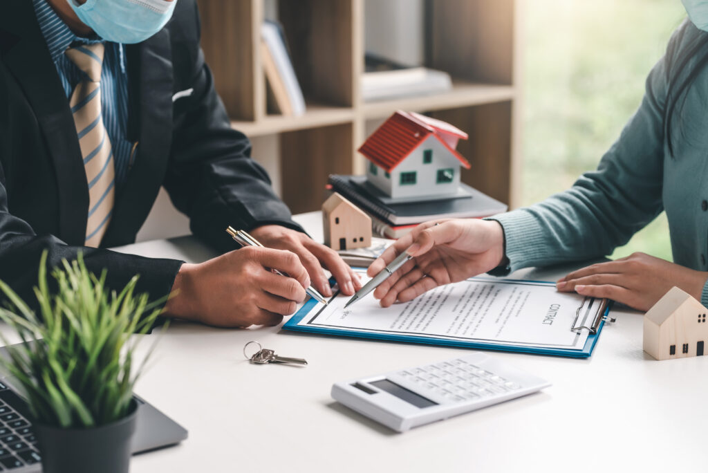 Close-up of real estate agent hand pointing at document signing